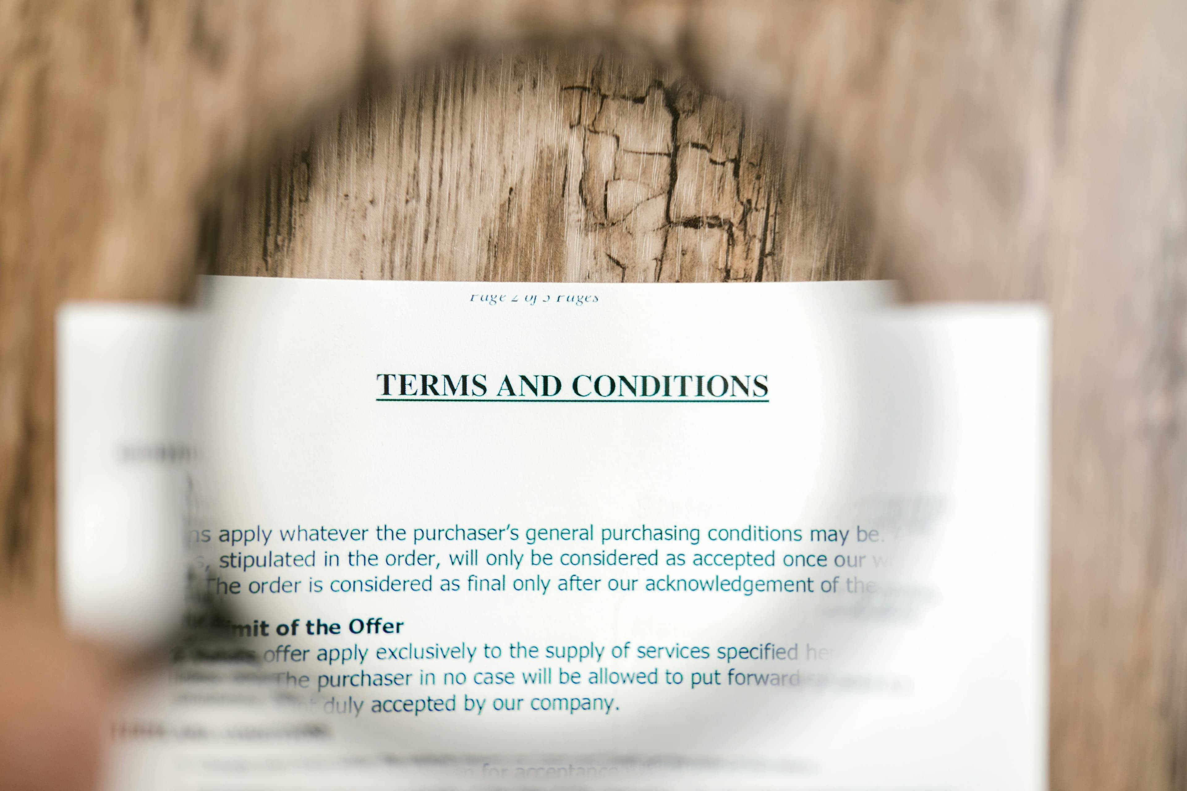 Magnifying glass focusing on the "Terms and Conditions" title of a contract